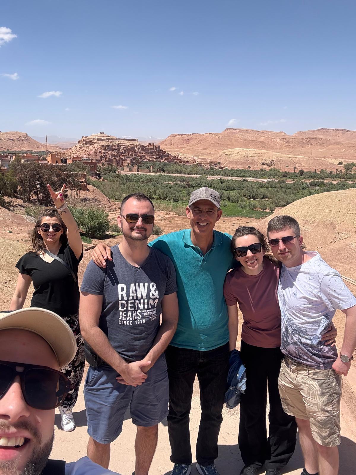 A group of travellers with their driver in front of Ait Ben Haddou
